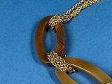 a picture of a necklace that is on a blue surface
