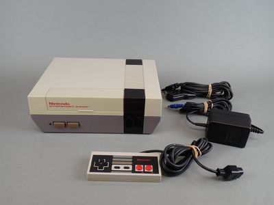 an old nintendo game console with a power cord and a charger