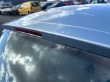 cars parked in a parking lot with a cloudy sky reflected in the rear window