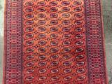 un tapis rouge et orange posé sur un sol en béton