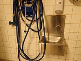 un tuyau bleu fixé au mur de des toilettes publiques