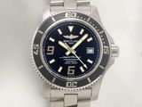 the watch is on a silver bracelet with a blue dial