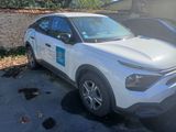 a white car parked in a parking lot next to a building