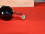 a bottle of wine sitting on a red table cloth