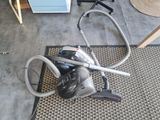un aspirateur posé par terre à côté d'un tapis