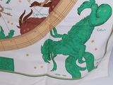 a green and white scarf with a picture of a scorpion on it