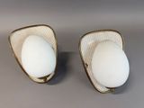 pair of white and gold plated sconces on a gray surface