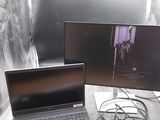deux ordinateurs portables posés sur une table, à côté d'un écran et d'un téléphone portable