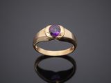 a gold ring with an amethe stone in the center