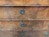 a wooden chest of drawers with a lion head on it