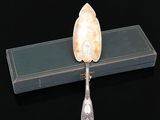 une cuillère en argent posée sur une boîte bleue