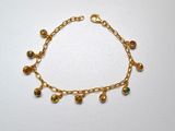 a close up of a gold bracelet with bells on it
