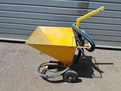 une petite machine jaune à laquelle est raccordé un tuyau