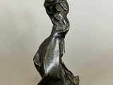 statue of a woman in a long dress holding a bird