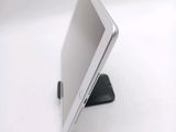 a tablet computer sitting on a stand on a white surface