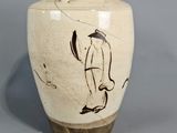 un vase orné d'un dessin sur un fond gris