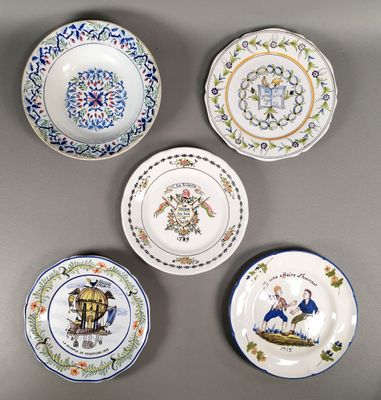 quatre assiettes ornées de motifs différents, posées sur un fond gris