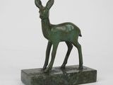 sculpture en bronze représentant un cerf, posée sur un socle en marbre, sur fond blanc