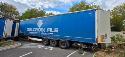 a large blue truck that is parked in a parking lot