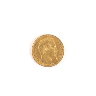 gros plan d'une pièce d'or sur une surface blanche
