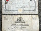 un vieux document orné d'un ruban rouge et d'une médaille