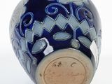 a blue vase with a design on it on a white surface