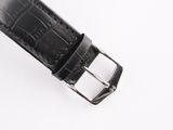 a close up of a black leather watch strap on a white surface