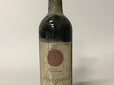 une vieille bouteille de vin posée sur une table blanche