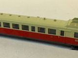 a red and white train on the tracks on a white surface