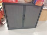 a grey cabinet with a door and a basket on top of it