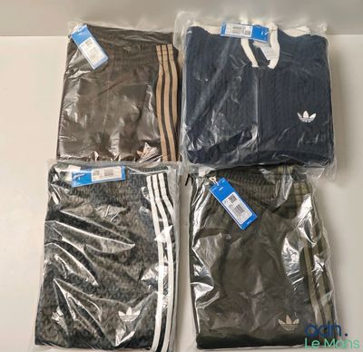three pairs of adidas t - shirts in plastic bags on a table