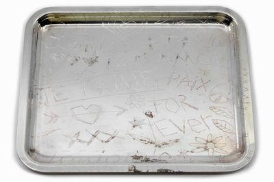 un plateau en argent comportant une inscription sur un fond blanc