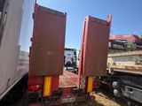 two trucks that are parked next to each other in the dirt