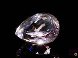 une image représentant un diamant posé sur une surface noire, sur fond noir