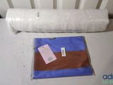 a roll of fabric sitting on a table next to a pillow