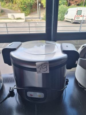 a silver and black electric rice cooker on a table