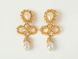 une paire de boucles d'oreilles en or ornées de perles sur fond blanc