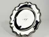 un plateau d'argent antique sur un support sur une surface blanche