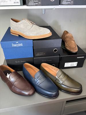 plusieurs paires de chaussures pour homme posées sur des cartons, sur une table