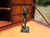 une statue de femme tenant une fleur à la main