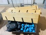 a metal basket filled with blue dumbs and a wooden crate