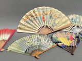 several different types of paper fans on a gray surface