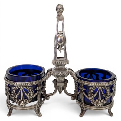 a pair of blue glass vases sitting on top of a metal stand