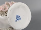 a white vase with a blue flower on it