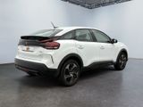 the rear end of a white car in a white room