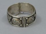 an antique silver bracelet with a design on the side
