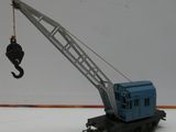 une petite grue en jouet suspendue à un crochet dans la neige
