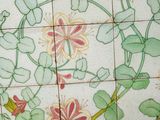 a picture of a tile with flowers and leaves on it