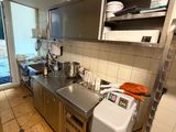 une cuisine dotée de nombreux plans de travail et d'appareils électroménagers en inox