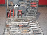 une caisse d'outils avec des outils à l'intérieur, posée sur le sol